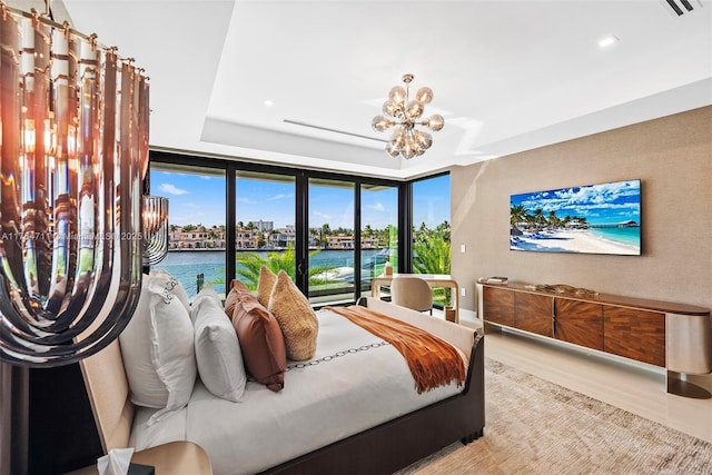 bedroom with a notable chandelier and a tray ceiling