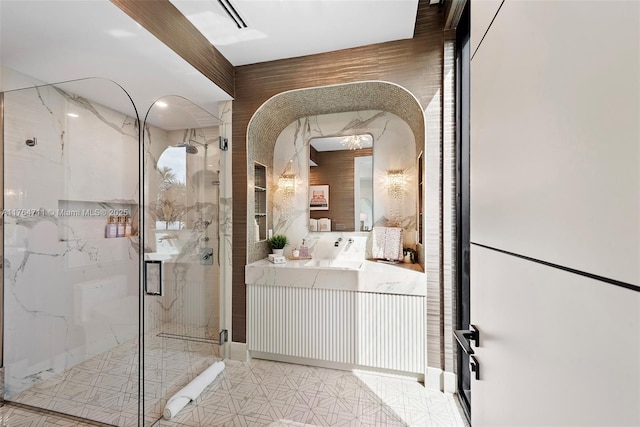 full bath featuring vanity and a marble finish shower