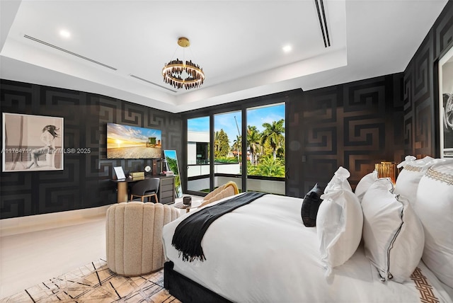 bedroom with a tray ceiling, an inviting chandelier, wallpapered walls, access to exterior, and an accent wall