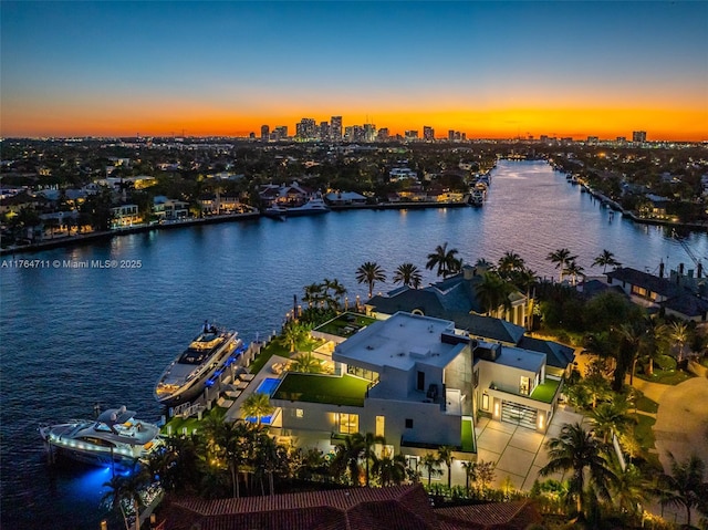 aerial view at dusk with a city view and a water view