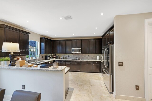 9835 NW 86th Ter, Doral, FL 33178 - kitchen featuring a peninsula, tasteful backsplash, dark brown cabinetry, and stainless steel appliances