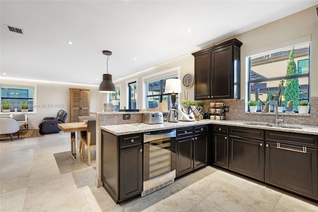 9835 NW 86th Ter, Doral, FL 33178 - kitchen featuring visible vents, a sink, open floor plan, wine cooler, and a peninsula