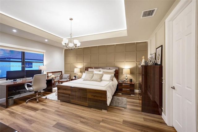 9835 NW 86th Ter, Doral, FL 33178 - bedroom with visible vents, a tray ceiling, wood finished floors, recessed lighting, and an inviting chandelier