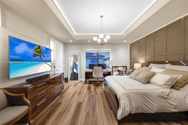 9835 NW 86th Ter, Doral, FL 33178 - bedroom with a chandelier, recessed lighting, wood finished floors, a decorative wall, and a raised ceiling