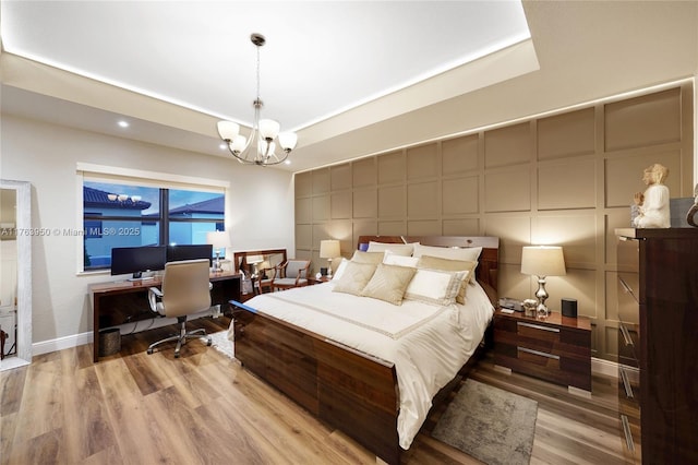9835 NW 86th Ter, Doral, FL 33178 - bedroom with a decorative wall, a tray ceiling, an inviting chandelier, and wood finished floors