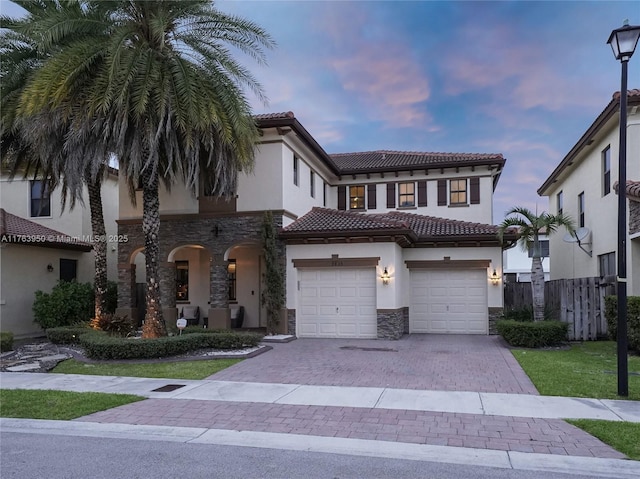 9835 NW 86th Ter, Doral, FL 33178 - view of front facade featuring stucco siding, driveway, a tile roof, stone siding, and fence