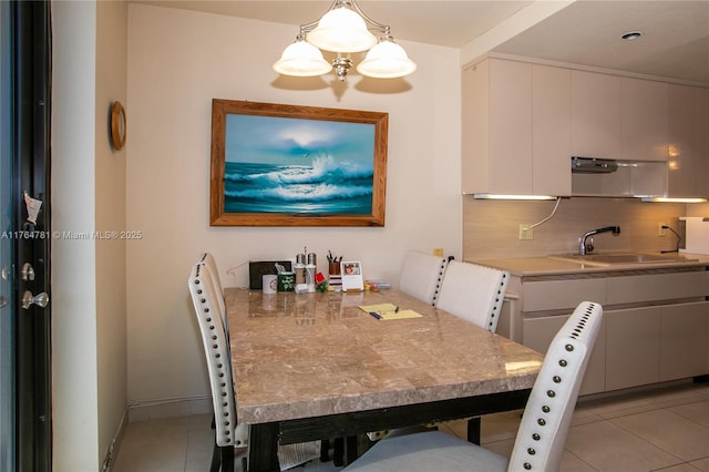 dining space with light tile patterned floors, baseboards, and a chandelier