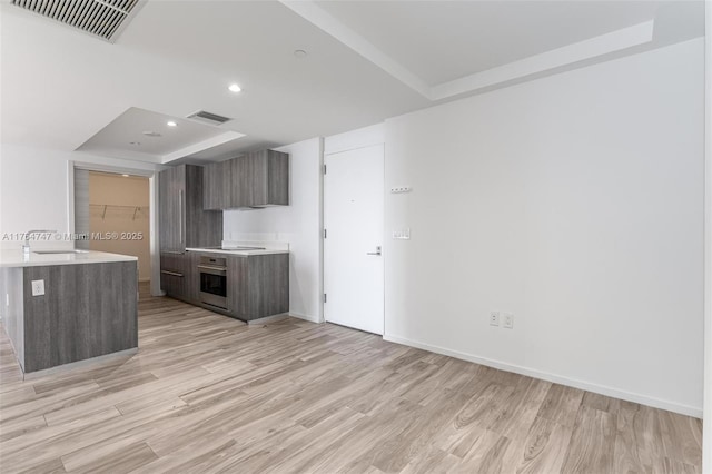 801 S Miami Ave Unit 3110, Miami, FL 33130 - kitchen featuring oven, modern cabinets, light countertops, a tray ceiling, and recessed lighting