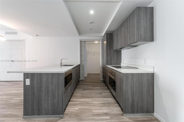 801 S Miami Ave Unit 3110, Miami, FL 33130 - kitchen with modern cabinets, appliances with stainless steel finishes, a peninsula, light countertops, and light wood finished floors