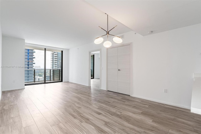 801 S Miami Ave Unit 3110, Miami, FL 33130 - unfurnished room featuring floor to ceiling windows, light wood-style flooring, a chandelier, and a smoke detector