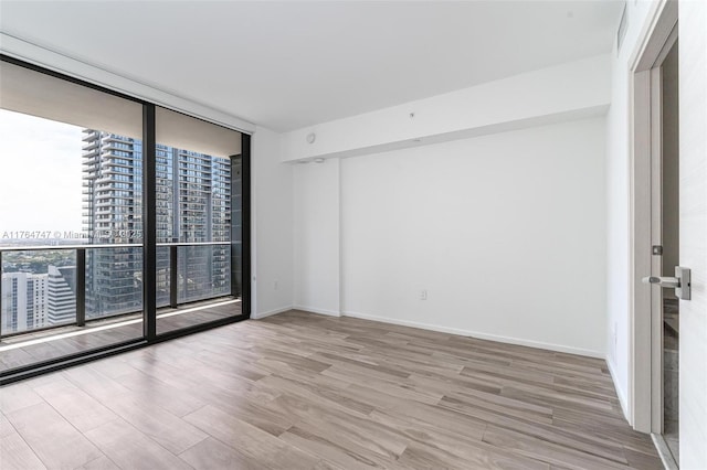 801 S Miami Ave Unit 3110, Miami, FL 33130 - empty room featuring a wall of windows, wood finished floors, and a view of city