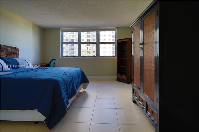 bedroom with light tile patterned flooring, baseboards, and a textured ceiling