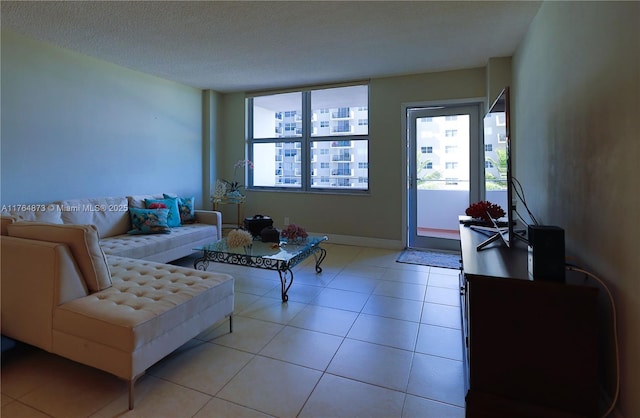 living area featuring baseboards, a textured ceiling, and light tile patterned flooring