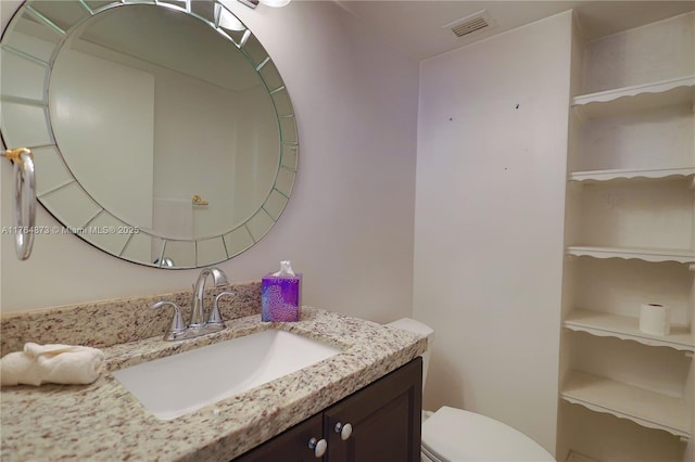 bathroom with visible vents, toilet, and vanity