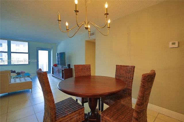 dining space with an inviting chandelier, light tile patterned floors, and baseboards