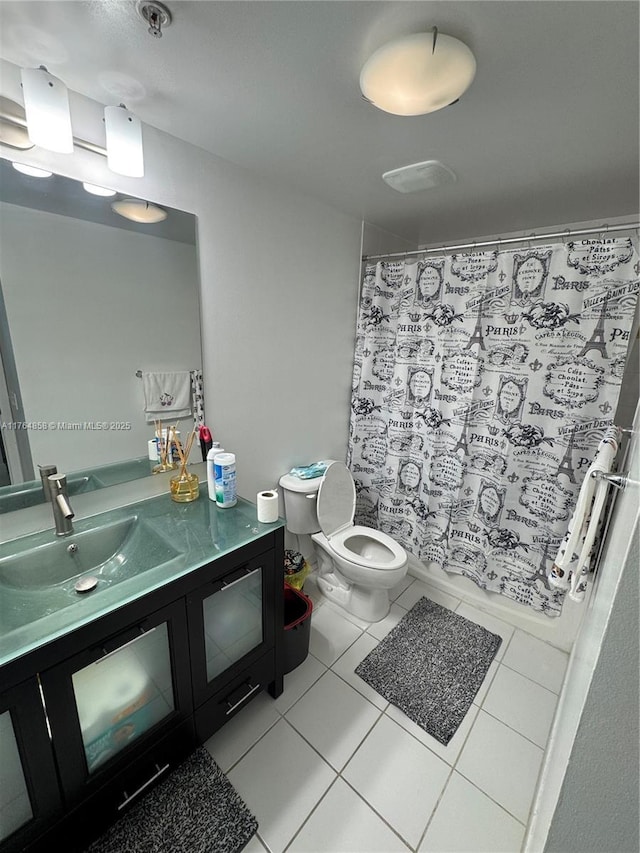 bathroom featuring tile patterned flooring, a shower with curtain, toilet, and vanity
