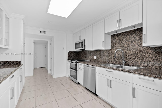 600 Grapetree Dr Unit 8Cs, Key Biscayne, FL 33149 - kitchen with stainless steel appliances, a sink, tasteful backsplash, white cabinetry, and dark stone counters