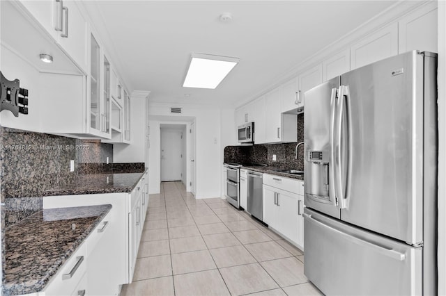 600 Grapetree Dr Unit 8Cs, Key Biscayne, FL 33149 - kitchen with stainless steel appliances, a sink, light tile patterned floors, white cabinetry, and backsplash