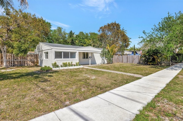 843 SW 20th St, Fort Lauderdale, FL 33315 - view of front of house featuring stucco siding, a front lawn, and fence