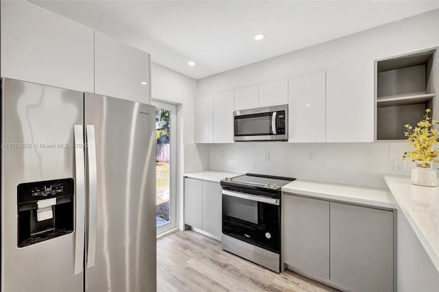 843 SW 20th St, Fort Lauderdale, FL 33315 - kitchen featuring white cabinetry, light wood-style flooring, appliances with stainless steel finishes, modern cabinets, and open shelves
