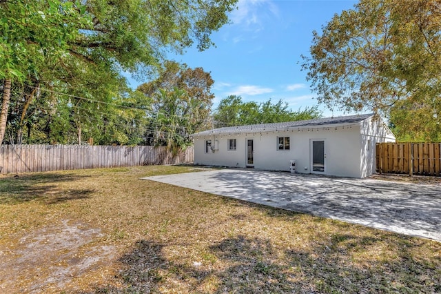 843 SW 20th St, Fort Lauderdale, FL 33315 - rear view of house with stucco siding, a patio area, a lawn, and fence