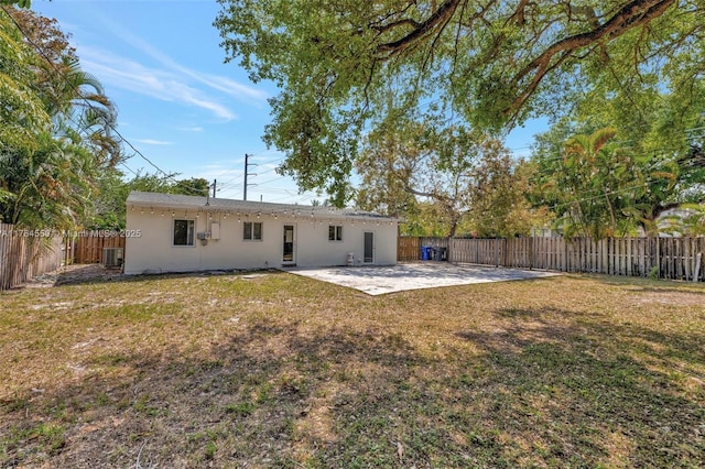 843 SW 20th St, Fort Lauderdale, FL 33315 - back of property featuring a yard, a patio area, a fenced backyard, and stucco siding
