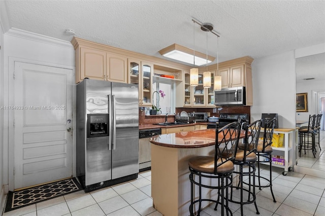 kitchen featuring stainless steel appliances, light tile patterned floors, cream cabinets, and dark countertops