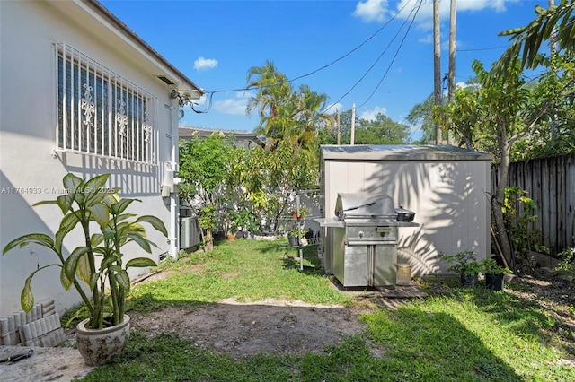 view of yard with a storage shed, a fenced backyard, and an outdoor structure