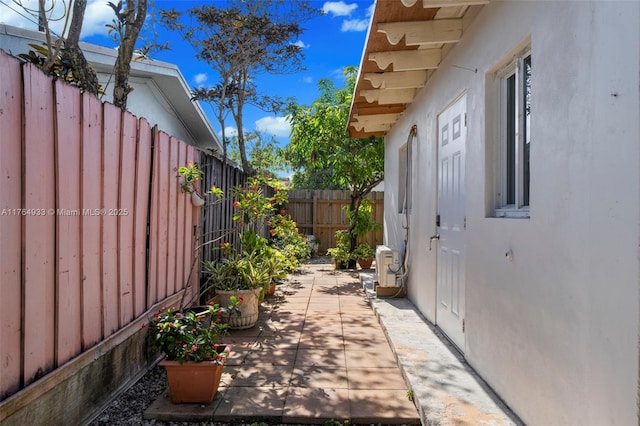 view of side of home featuring a patio, a fenced backyard, and stucco siding