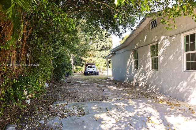 view of side of property with stucco siding and driveway