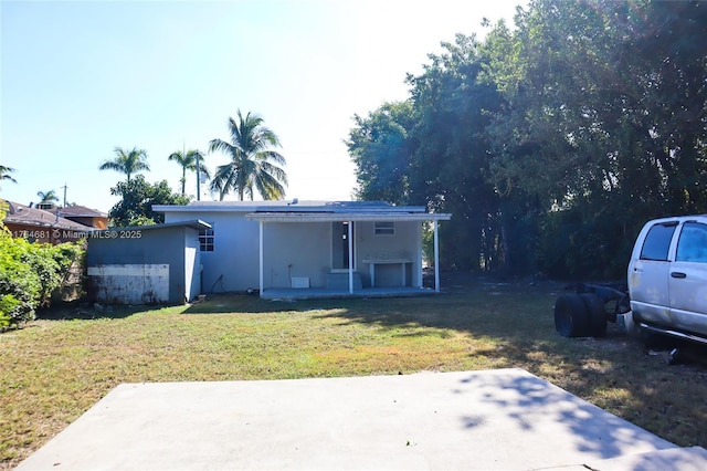 back of house with a patio area, a lawn, and stucco siding