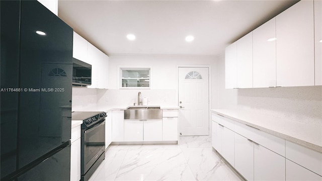 kitchen with marble finish floor, black appliances, a sink, white cabinetry, and light countertops