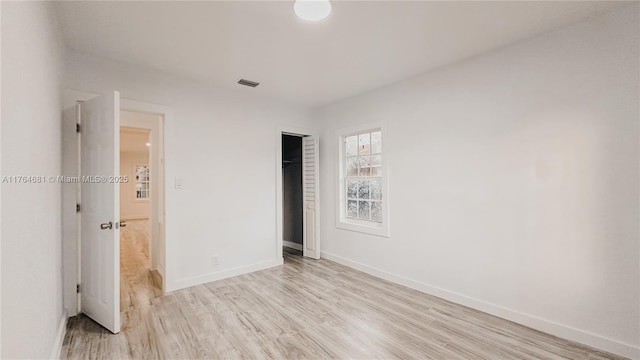 unfurnished bedroom featuring a closet, visible vents, light wood-style flooring, and baseboards