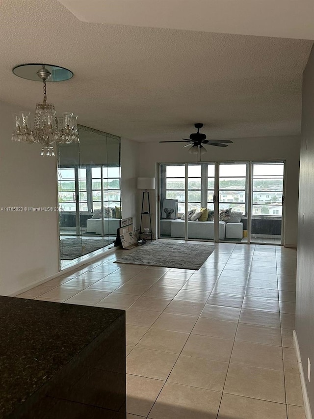 1101 Crystal Lake Dr Unit 602, Deerfield Beach, FL 33064 - interior space with a textured ceiling, a healthy amount of sunlight, light tile patterned flooring, and ceiling fan with notable chandelier