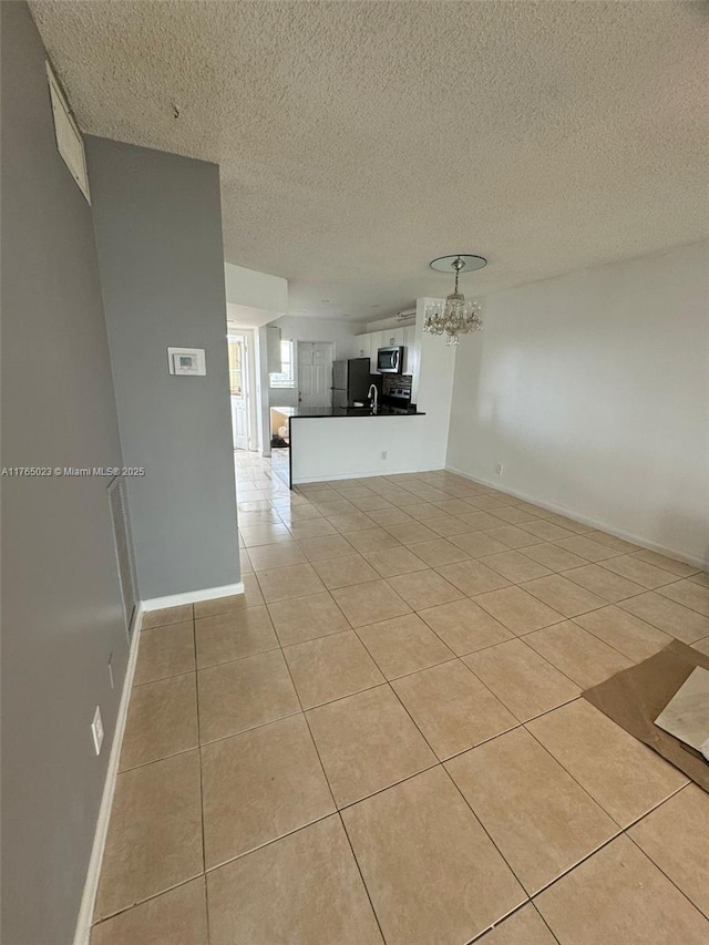 1101 Crystal Lake Dr Unit 602, Deerfield Beach, FL 33064 - spare room featuring an inviting chandelier, light tile patterned flooring, baseboards, and a textured ceiling