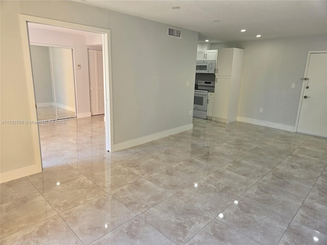 empty room with recessed lighting, visible vents, and baseboards