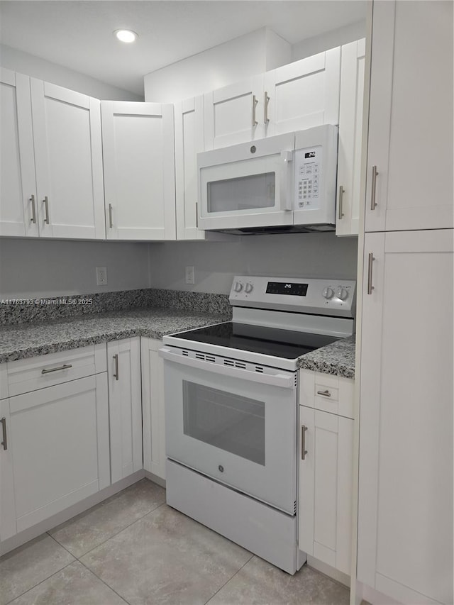 kitchen featuring white appliances, white cabinets, light tile patterned floors, and recessed lighting