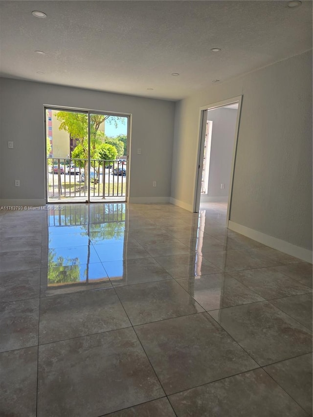 empty room featuring baseboards and a textured ceiling