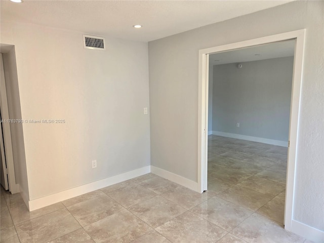 empty room with recessed lighting, visible vents, and baseboards