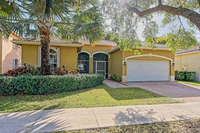 mediterranean / spanish home with a tile roof, decorative driveway, an attached garage, and stucco siding