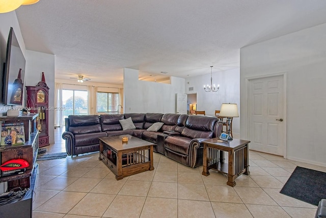 living room with an inviting chandelier, light tile patterned floors, baseboards, and a textured ceiling