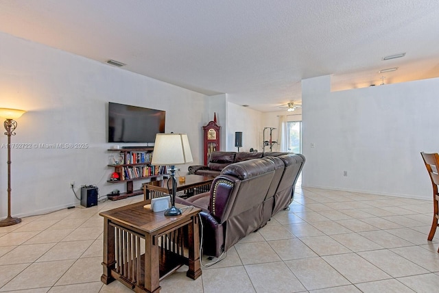 living area with light tile patterned floors, visible vents, a textured ceiling, and a ceiling fan