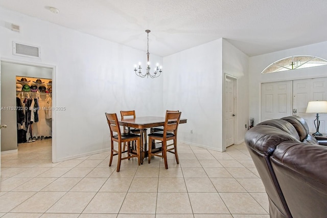 dining area with a notable chandelier, visible vents, light tile patterned floors, and a textured ceiling