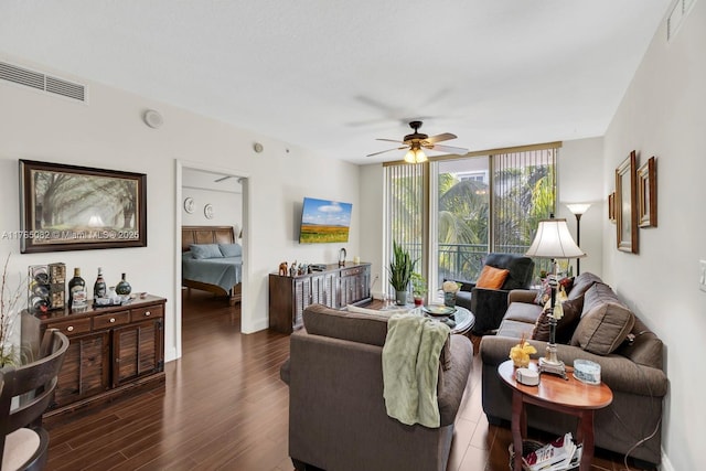 living area featuring visible vents, baseboards, ceiling fan, and dark wood-style flooring