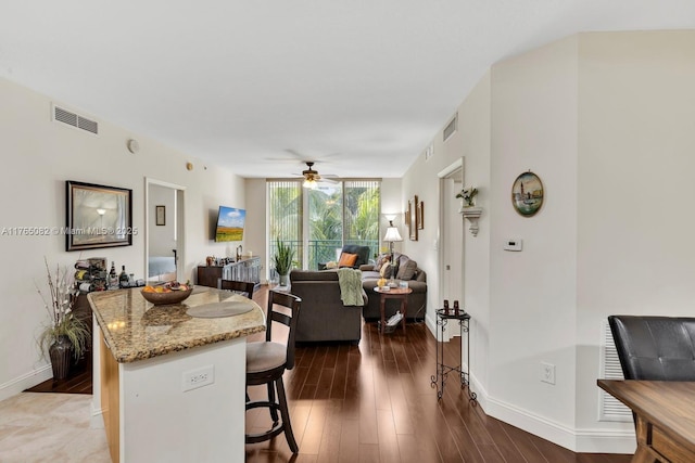interior space with dark wood finished floors, visible vents, and a ceiling fan