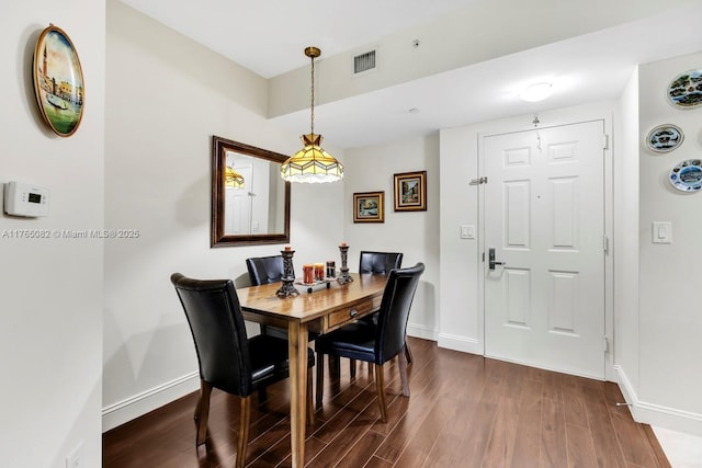 dining area with visible vents, baseboards, and dark wood-style floors
