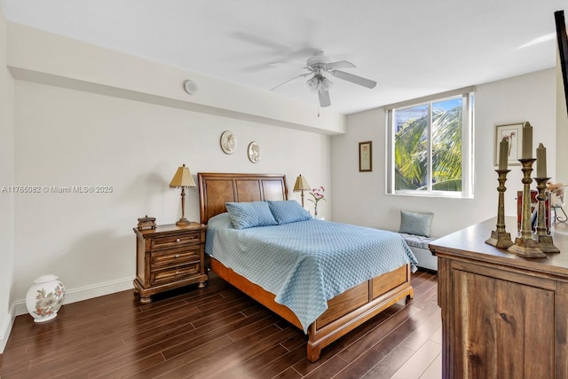 bedroom with dark wood-style floors, ceiling fan, and baseboards