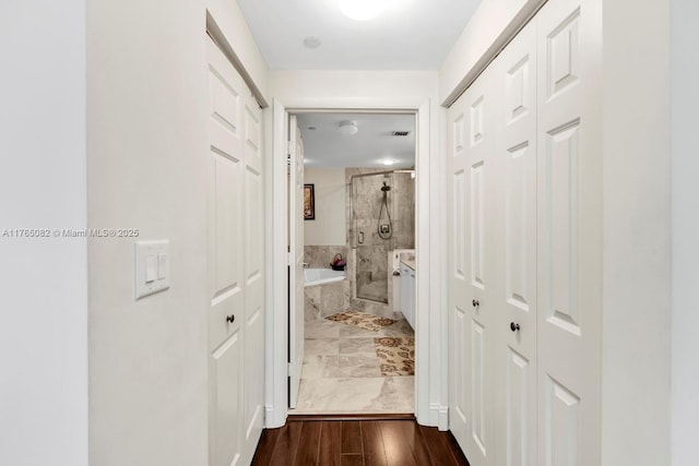 corridor featuring dark wood finished floors and visible vents