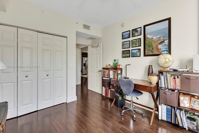 home office featuring visible vents, baseboards, and wood finished floors