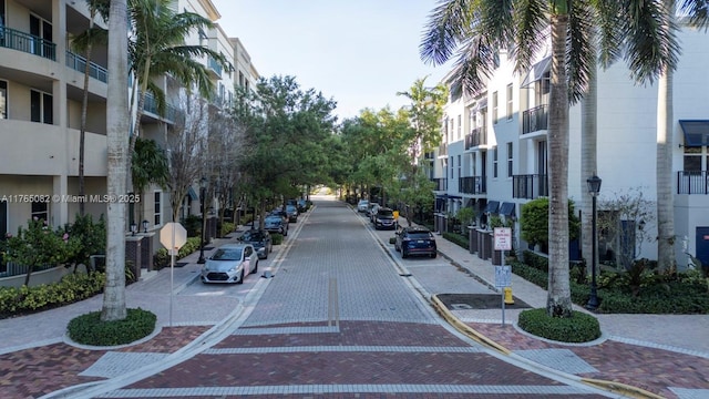 view of street with traffic signs, curbs, street lights, and sidewalks